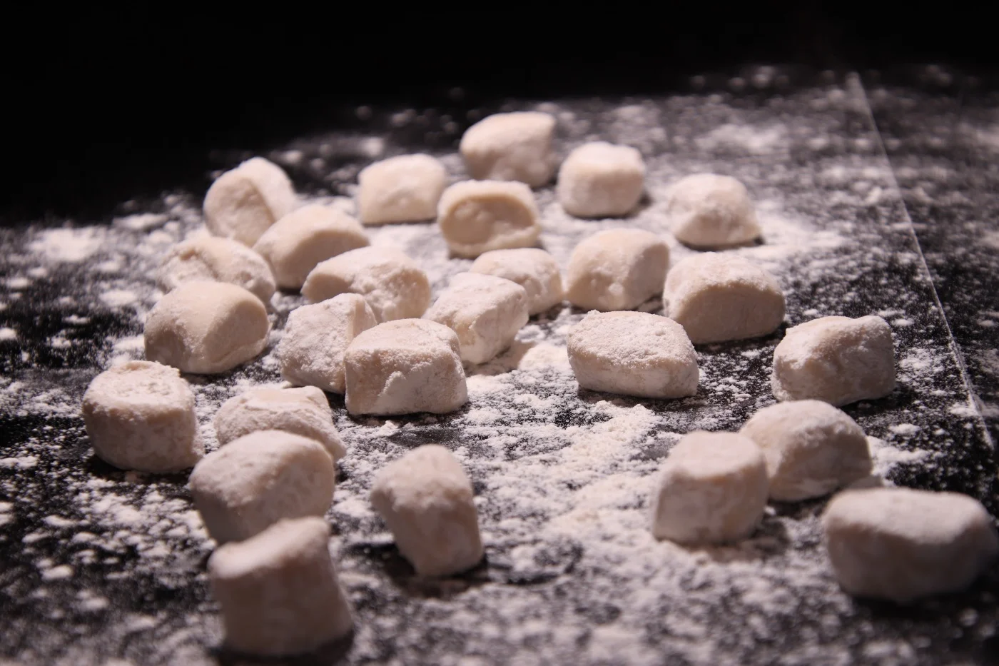 Fresh gnocchi being handmade on a floured worktop