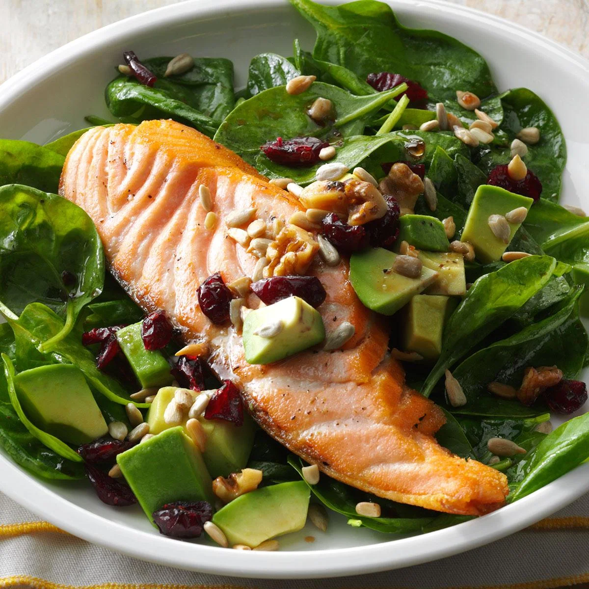 Salmon and avocado salad with spinach and seeds